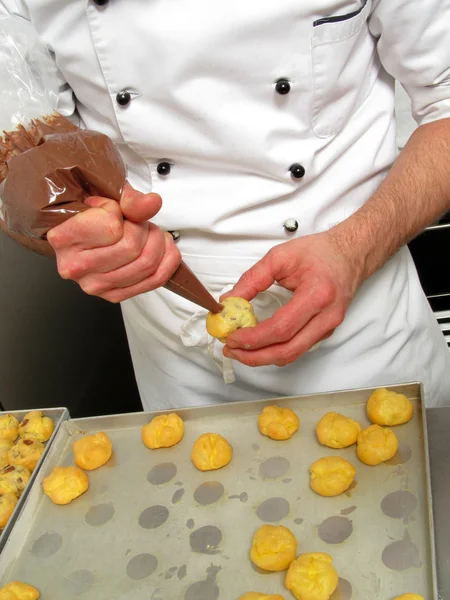 Un cocinero prepara pasteles — Stockfoto