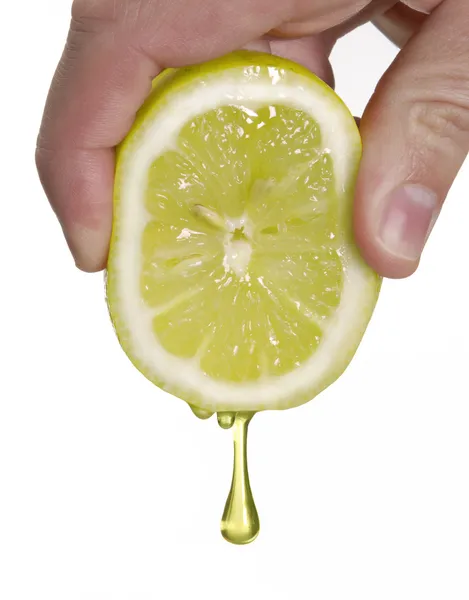 Рука сжимает лимон, лимонную каплю — стоковое фото