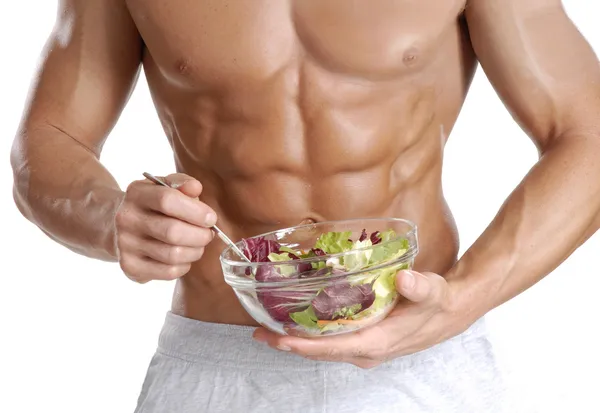 Homem de corpo em forma e saudável segurando uma tigela de salada fresca, em forma abdominal — Fotografia de Stock