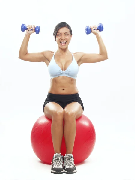 Junge Frau macht Fitnesstraining mit rotem Ball. — Stockfoto