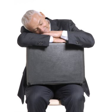 Bavulunu üzerinde oturan üst düzey iş adamı.