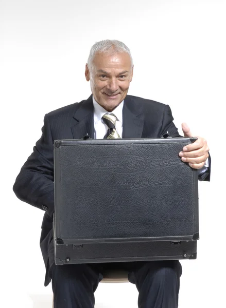 Happy senior businessman holding a suitcase on white background. — Stock Photo, Image