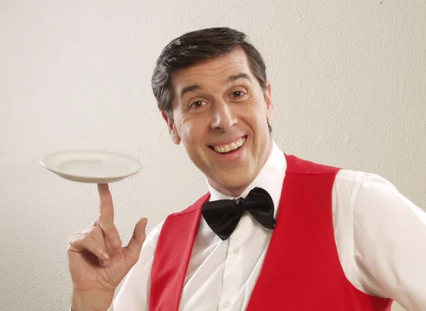 Expressive waiter holding an empty plate. — Stock Photo, Image