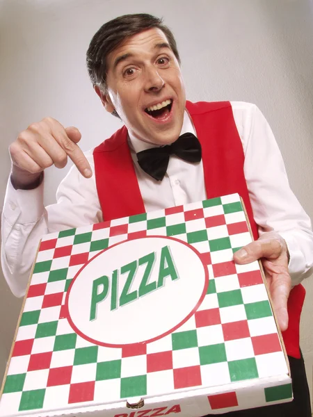 Доставщик пиццы указывает на коробку с пиццей — стоковое фото