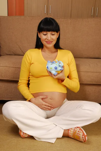 Joven y feliz embarazada sosteniendo una alcancía , — Foto de Stock