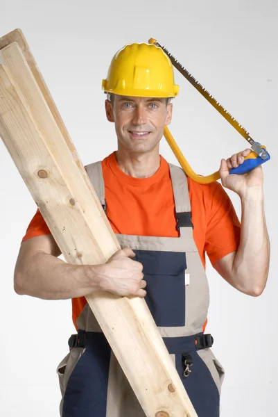 Werknemer holding houten planken en zag. — Stockfoto