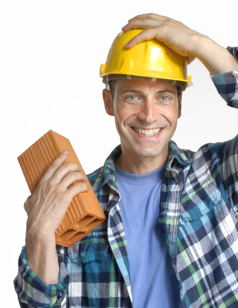 Homem de construção segurando um tijolo de parede no fundo branco . — Fotografia de Stock