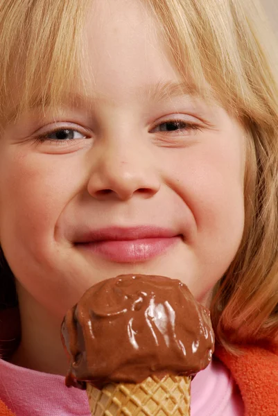 Klein meisje eten een chocolade-ijs. — Stockfoto