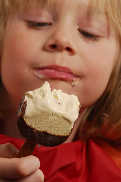 Klein meisje eten een chocolade-ijs. — Stockfoto