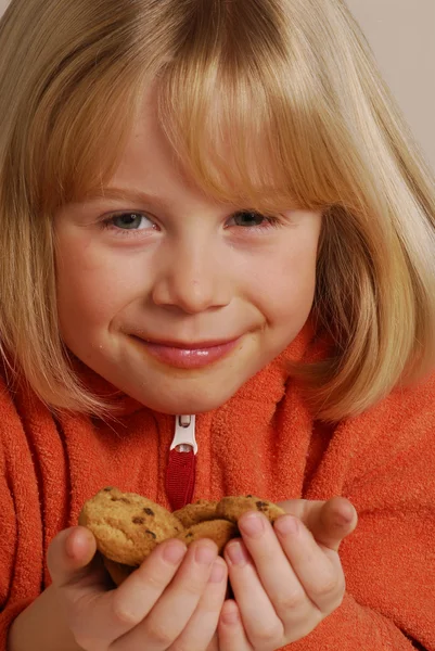 小女孩吃饼干，持有 cookie 的孩子. — 图库照片