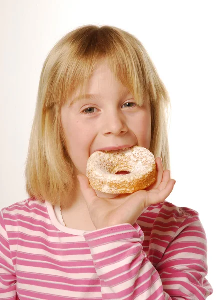 Lilla flickan äta kakan. liten unge äta vanilj cake. — Stockfoto