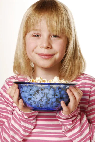 Liten flicka äter popcorn. lilla ungen äter pop corn. — Stockfoto