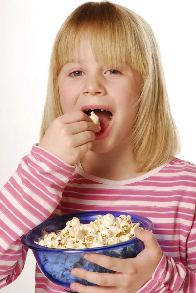 Klein meisje eten popcorn. kleine kind eten pop corn. — Stockfoto