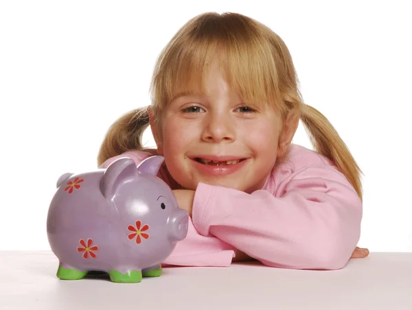Liten flicka att spara pengar med hjälp av en spargris. — Stockfoto