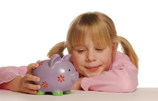 Küçük kız bir kumbara kullanarak para tasarrufu. — Stok fotoğraf