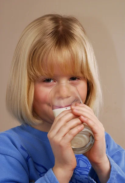 Liten flicka som håller ett glas mjölk — Stockfoto