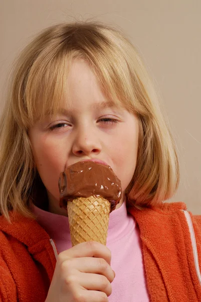 Menina comendo um sorvete de chocolate . — Fotografia de Stock