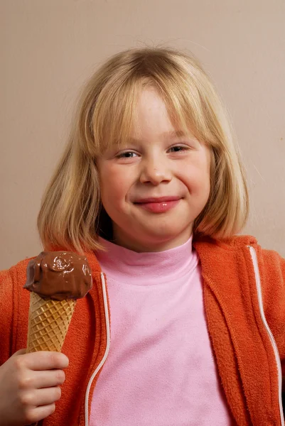 Klein meisje eten een chocolade-ijs. — Stockfoto