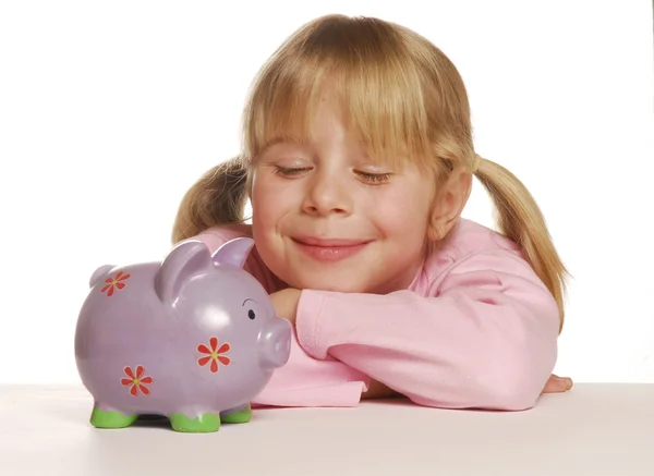 Little girl saving money using a piggy bank. — Stock Photo, Image