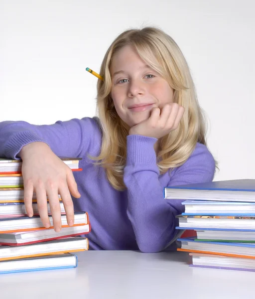 Schulmädchenporträt hinter Büchern. — Stockfoto