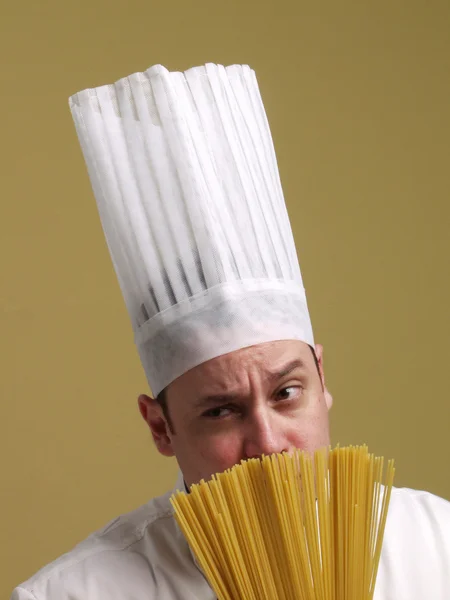 Unga kocken innehar en pasta tallrik. — Stockfoto