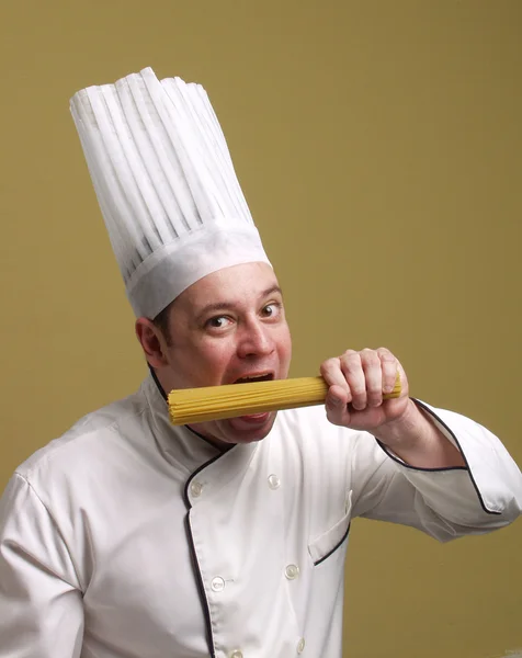 Jovem chef segurando um prato de massa . — Fotografia de Stock