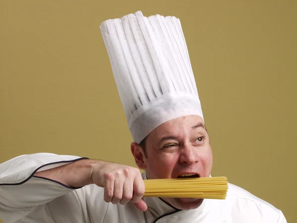 Joven chef sosteniendo un plato de pasta . — Foto de Stock