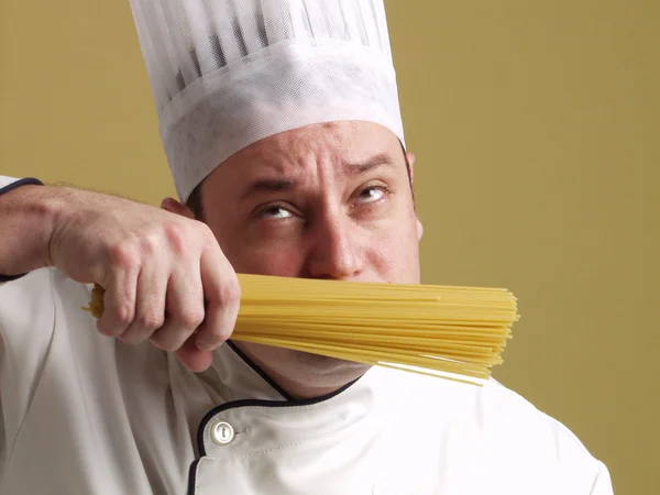 Joven chef sosteniendo un plato de pasta . —  Fotos de Stock