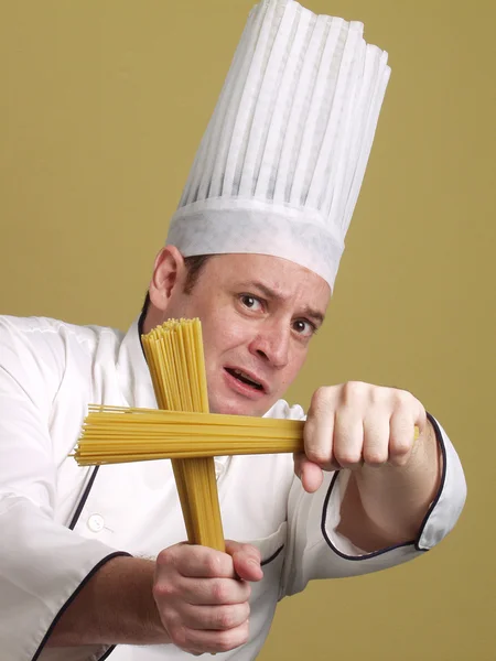 Joven chef sosteniendo un plato de pasta . —  Fotos de Stock