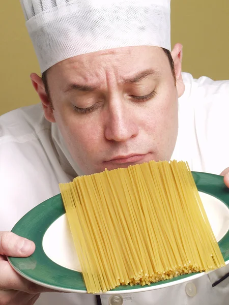 Unga kocken innehar en pasta tallrik. — Stockfoto