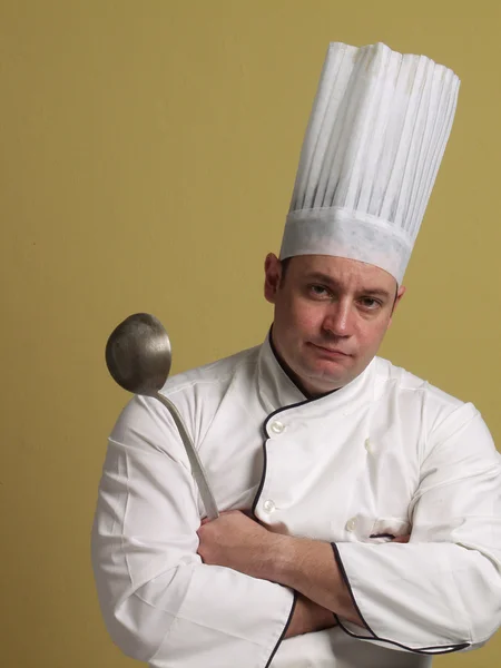 Portrait of a young chef on yellow background. — Stock Photo, Image