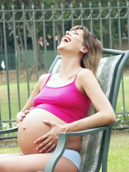 Mujer embarazada sentada en un sillón al aire libre — Foto de Stock