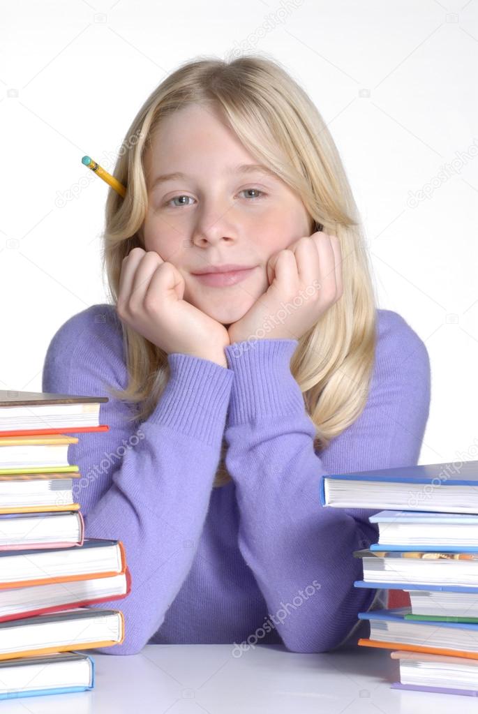 School girl portrait behind books.