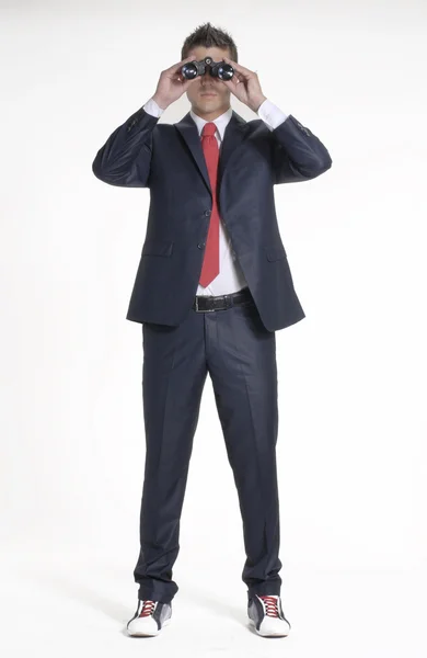 Young businessman looking through binoculars. — Stock Photo, Image