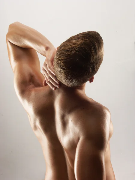 Formado y joven hombre estirando sus músculos —  Fotos de Stock