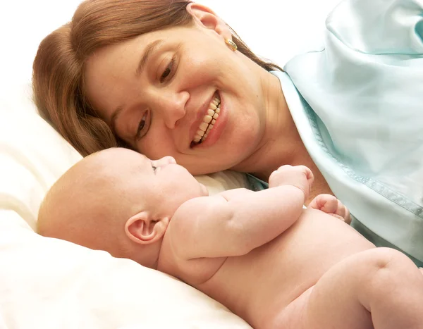 Spansktalande mamma njuter av hennes barn. mor och nyfödda njuter i sängen — Stockfoto