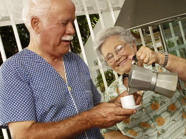 Gelukkig grootouders paar drinken koffie in de keuken. — Stockfoto