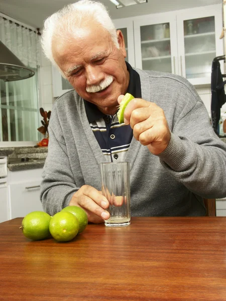 Grand-père faisant de la lime fraîche dans une cuisine — Photo