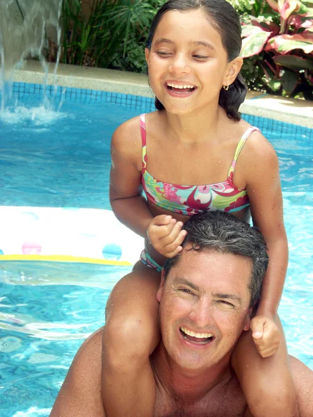 Hispanic father and daughter enjoying a swimming pool. — Stock Photo, Image