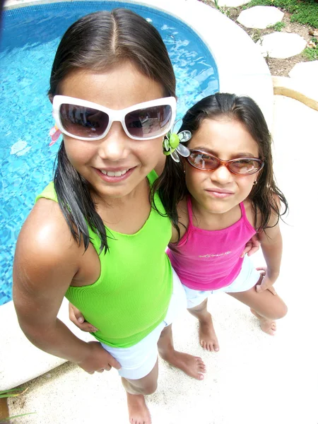 Hispanic girl with sunglasses enjoying a swimming pool. — Stock Photo, Image