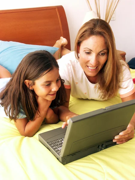 Madre e hija hispanas mirando el portátil —  Fotos de Stock