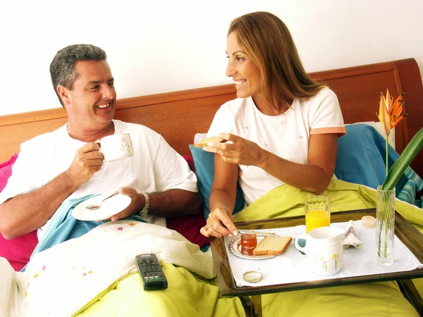 Casal hispânico tomando café da manhã na cama . — Fotografia de Stock