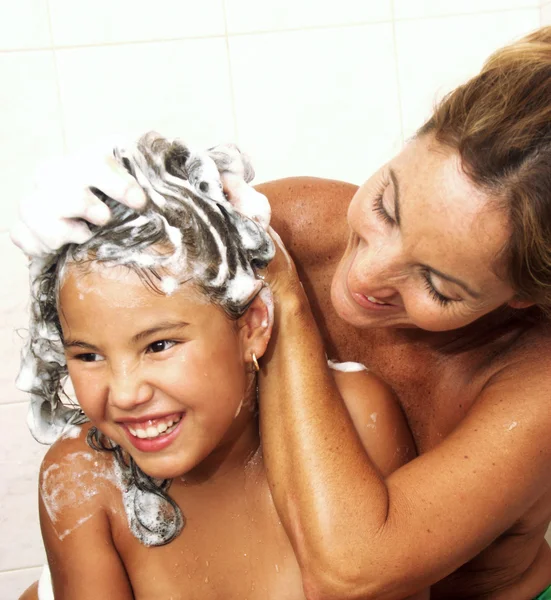 Mãe hispânica e filha wasing no chuveiro — Fotografia de Stock