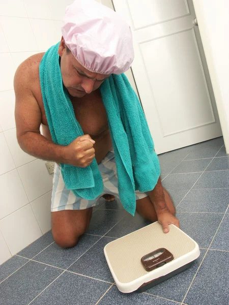 Hombre usando una báscula de peso en un baño . — Foto de Stock