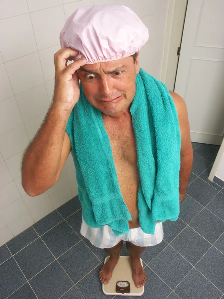 Hombre usando una báscula de peso en un baño . — Foto de Stock