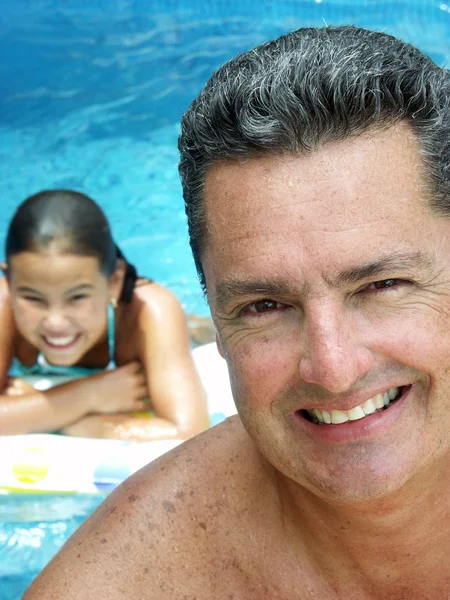 Hispanic father and daughter enjoying a swimming pool. — Stock Photo, Image