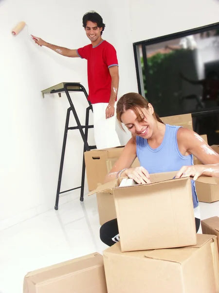 Jovem casal hispânico trabalhando e se mudando para uma nova casa . — Fotografia de Stock