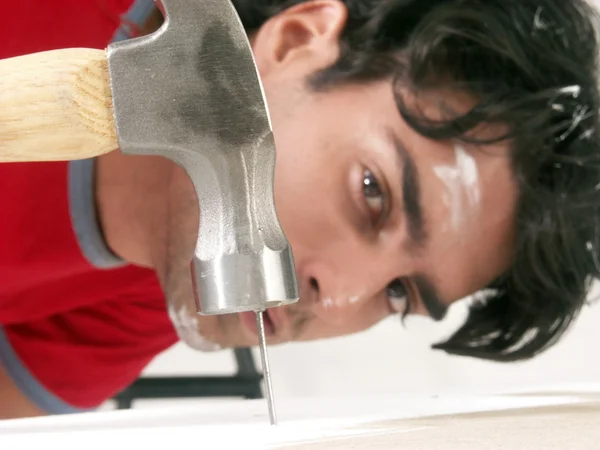 Joven martillando un clavo . — Foto de Stock