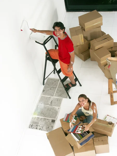 Jovem casal hispânico trabalhando e se mudando para uma nova casa . — Fotografia de Stock