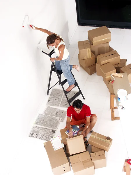 Jovem casal hispânico trabalhando e se mudando para uma nova casa . — Fotografia de Stock